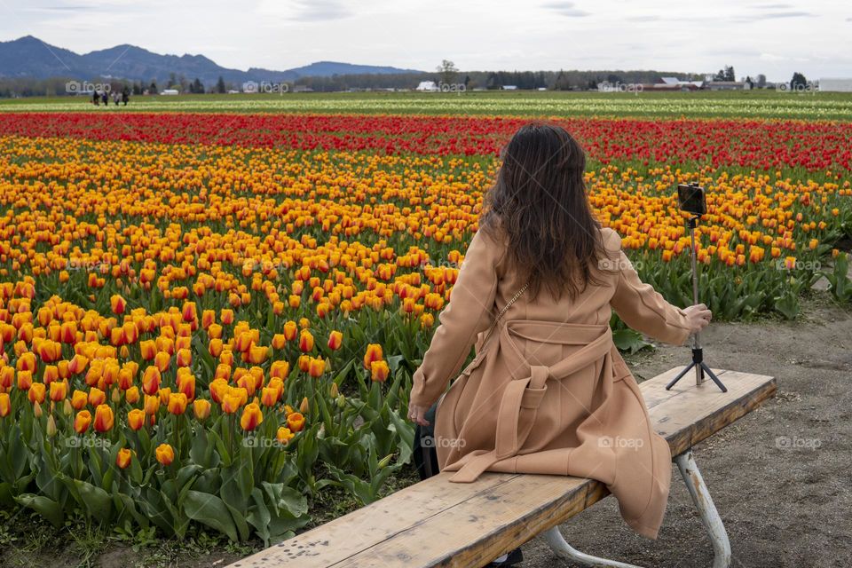 Woman taking selfie on the tulip field 