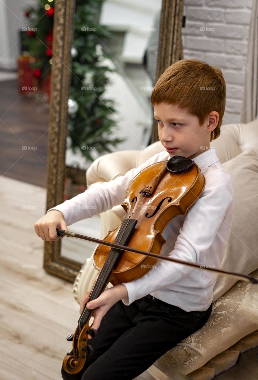 Redhead boy playing violin 