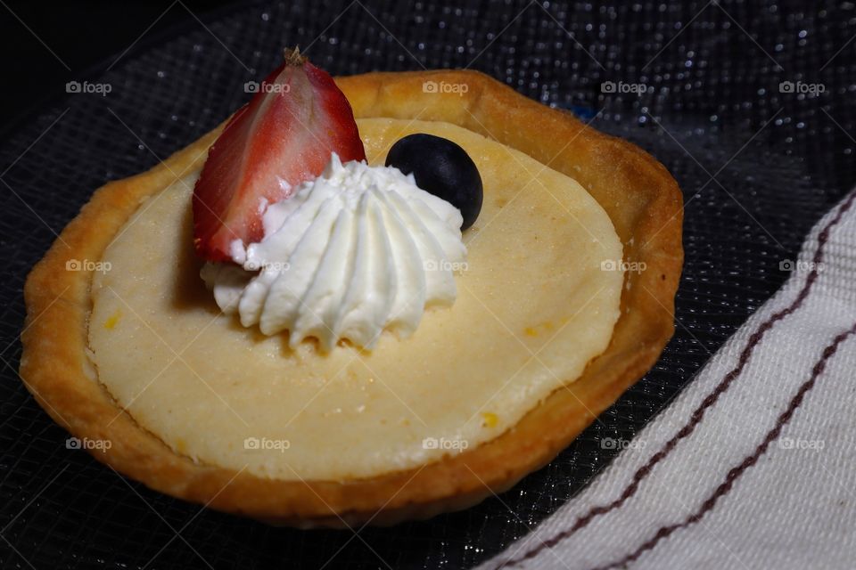 Lemon pie with whipped cream and a strawberry