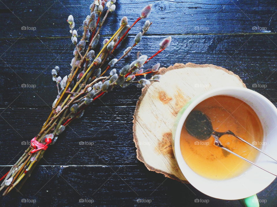 cup of tea and willow branches on a black background