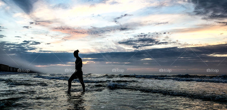 young man with man bun to sea.
