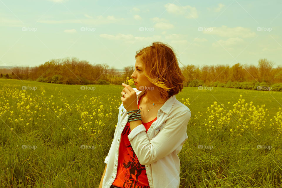 Woman smelling a flower in a field