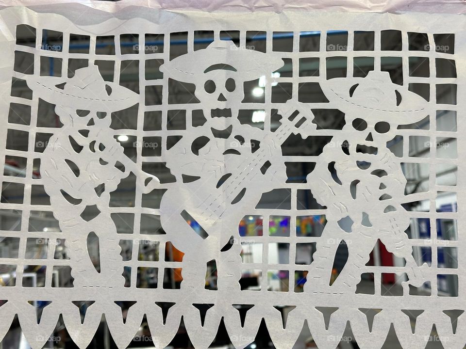 Funny skeleton figures on a white paper, dancing and playing instruments.