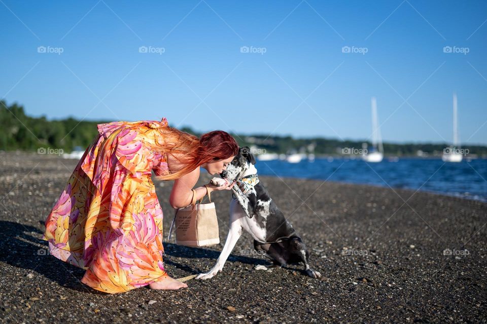 The princess is given kisses on the beach and she accepts the kisses. Paw in hand and hand in paw 