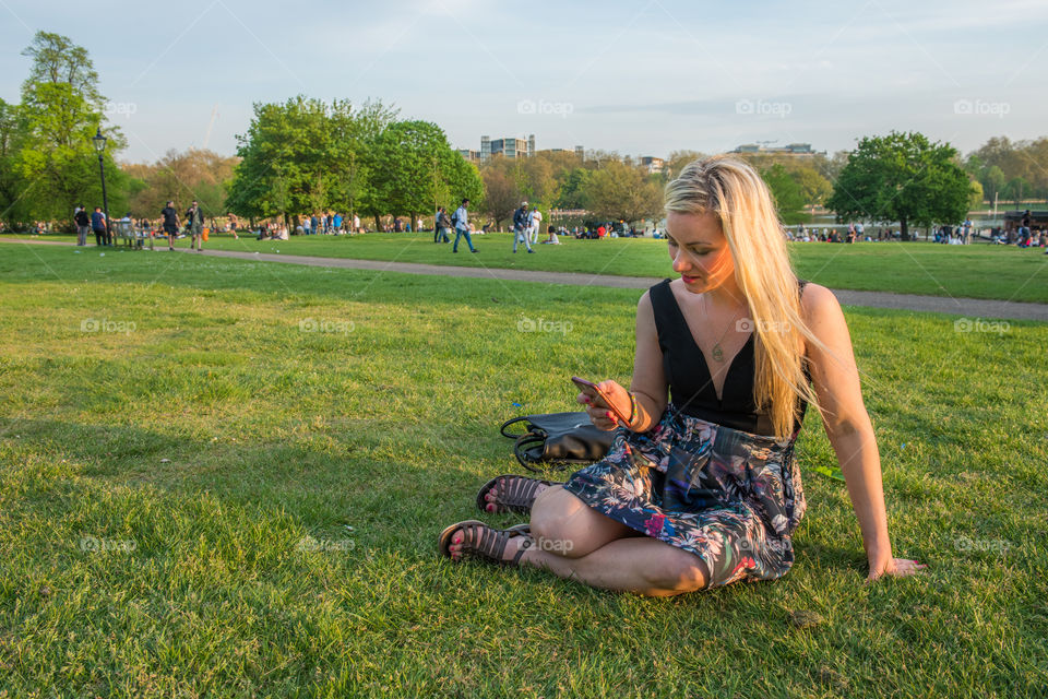 Woman tourist from Sweden 30 years plus taking a selfie in Hyde park in London.