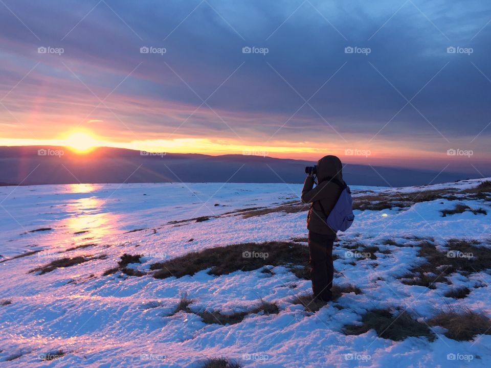 Photographer taking photo of Sunset in winter