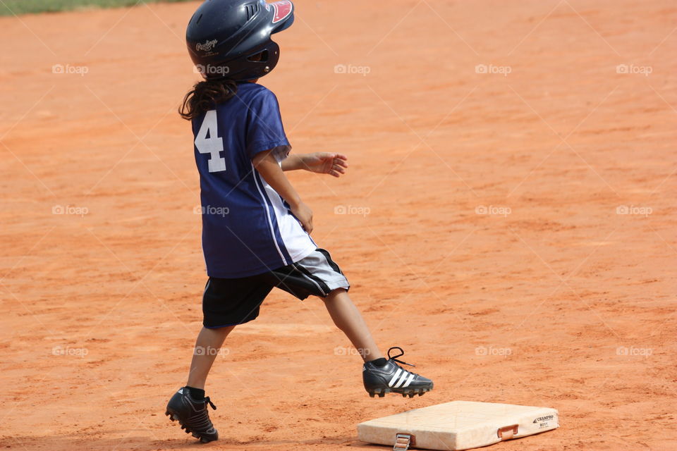 Child playing baseball running to base 