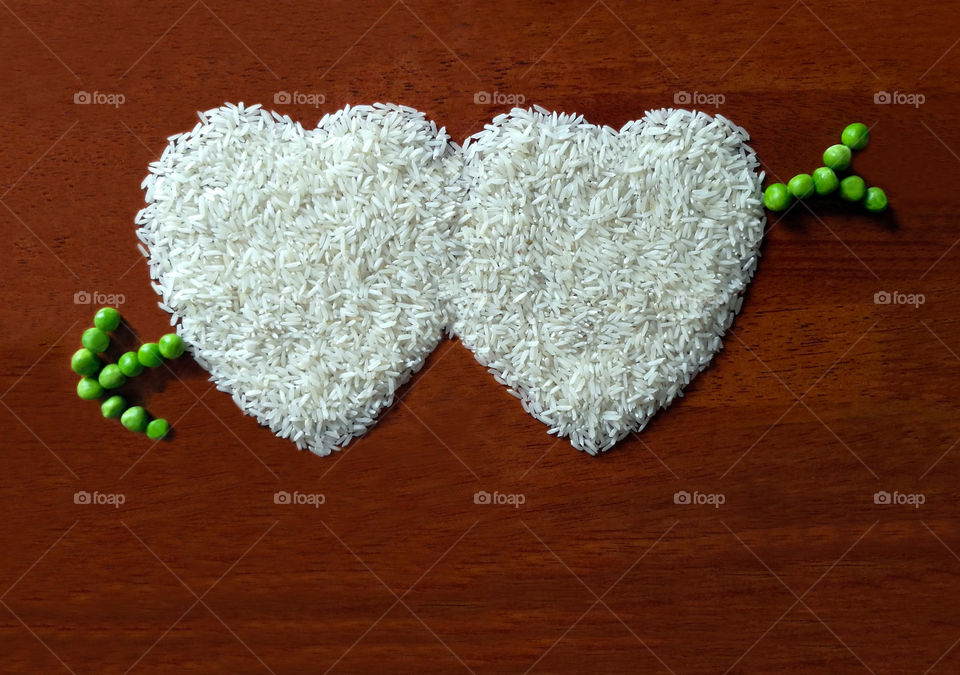 Heart shape of rice with green peas arrow with copy space. Concept of valentine and love card and background.