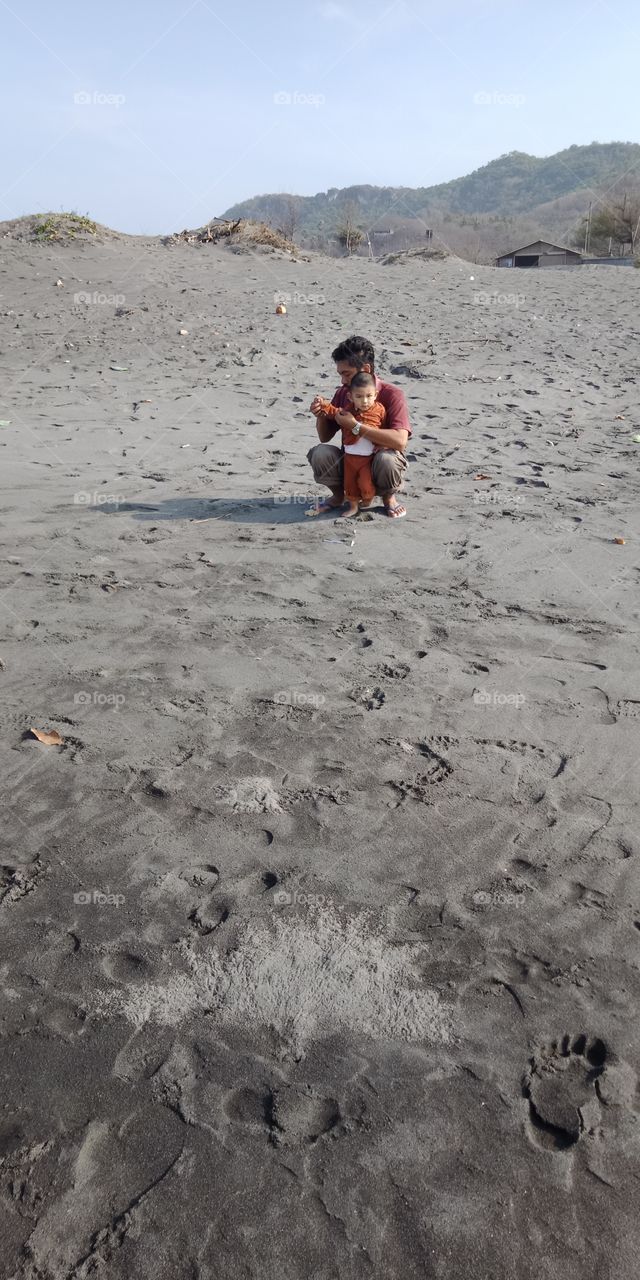 a man and a little kid recreation at beach