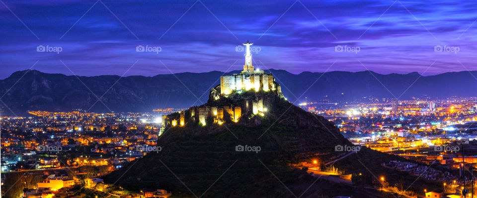 Panoramic view of Monteagudo Christ statue and castle at night in Murcia, Spain. Replica of the well-known Christ located on the top of the Concorvado Mountain in Rio de Janeiro