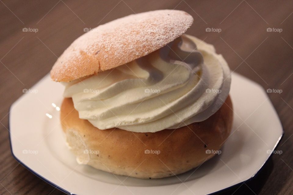 A wheat bun filled with whipped cream and almonds