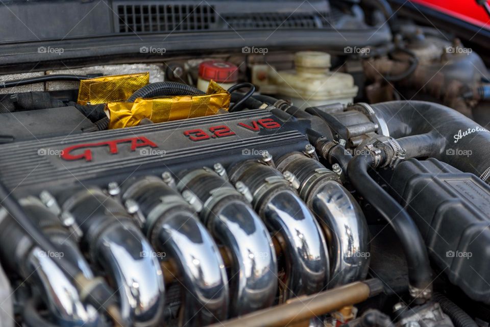 Close-up of an alfa romeo v6 engine with shiny chrome parts