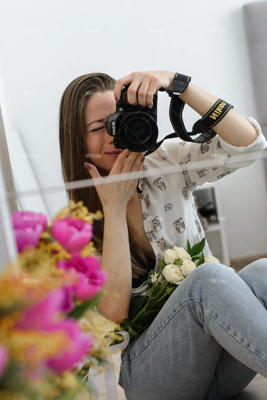 Beautiful young girl photographer taking a selfie in the mirror