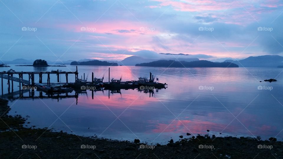 Sitka Sunset. Set in Sitka Alaska, the clouds play shades of pink orange and red with the mountains looking dark blue