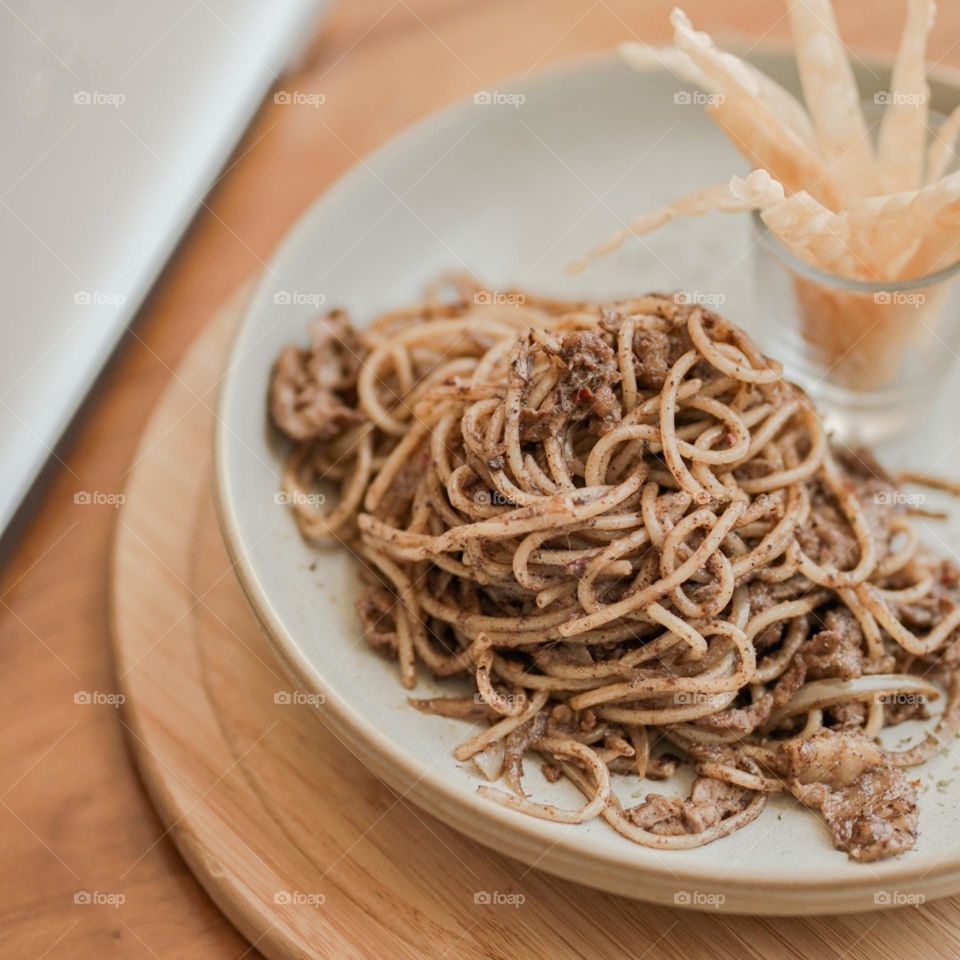 Close-up of noodles in plate on table. Food. Eat. Lunch. Breakfast. Snacks. Dessert. Photography. Aesthetic. Isolated background. Pastel colors. Table. Wood motifs. Cafe. Noodle. Tranquil. Delicious.