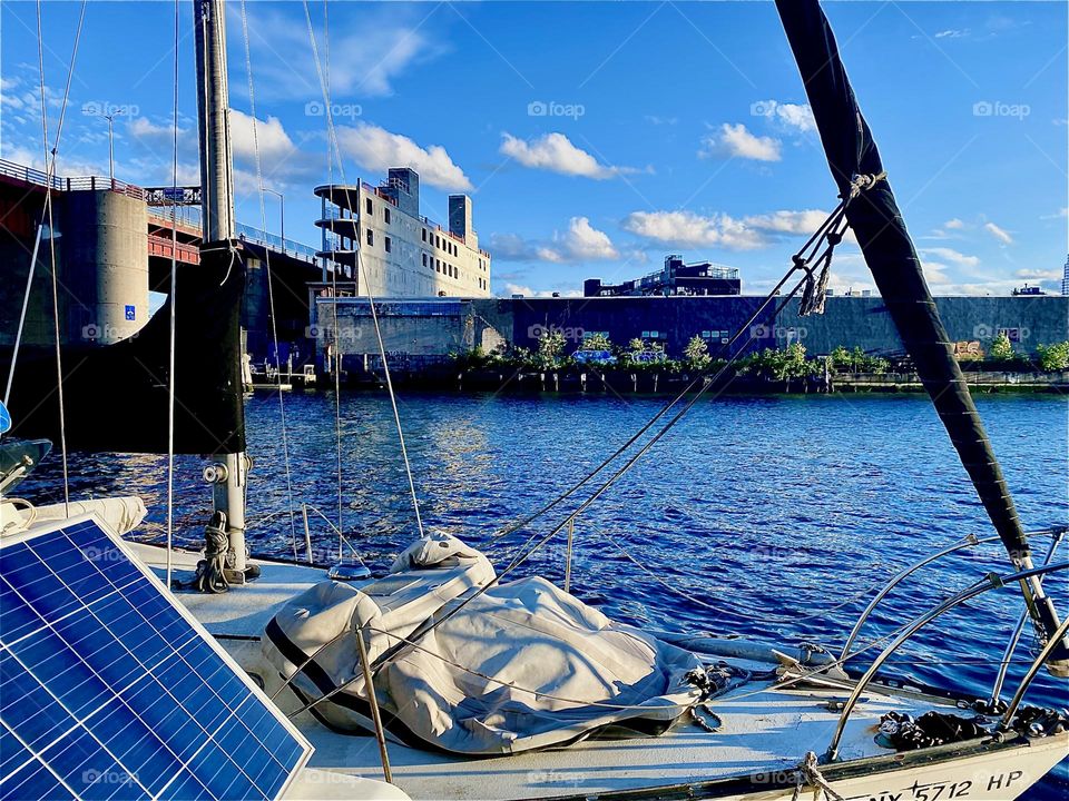 This is the view of the “Pulaski Bridge” at “Newtown Creek” on the far left, as well as of “Greenpoint”, Brooklyn across the “East River”. The setting evening sun lends a warm golden glow to everything in this picture. 2023. Hypnotic Productions