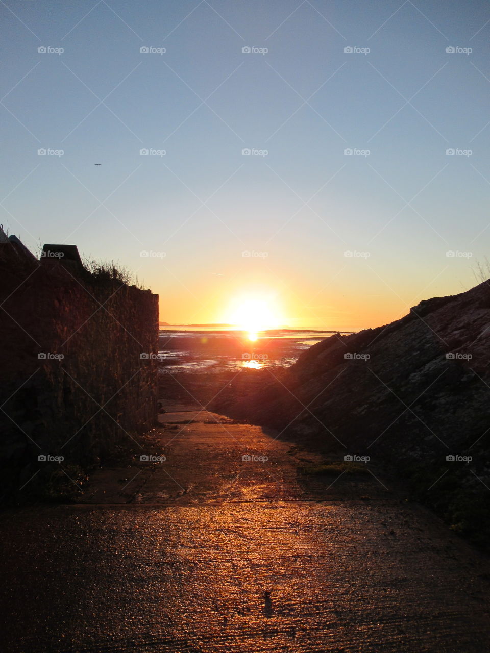 Sunset with a beautiful glow of light on the path leading down to the sea