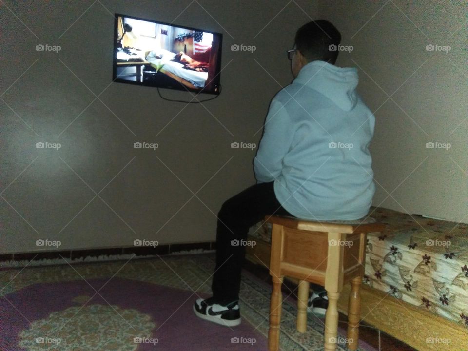 A young boy watching a  movie film.