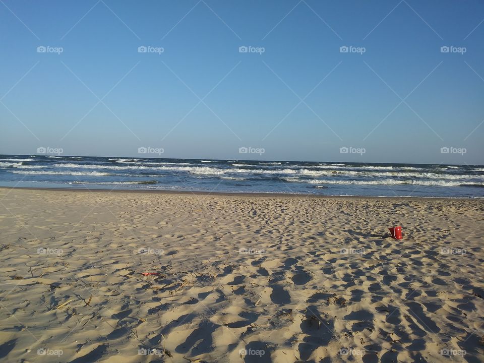 Shot of the beach. Red bucket to set the scene
