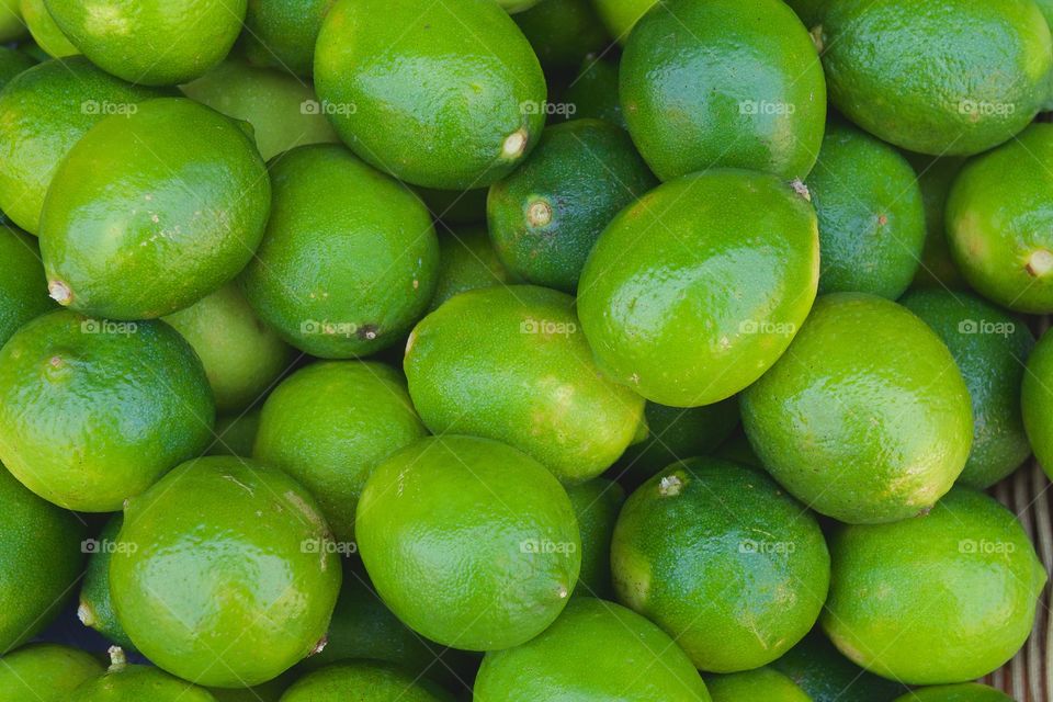 Fresh green limes displayed for sale  outside of a market in New York City
