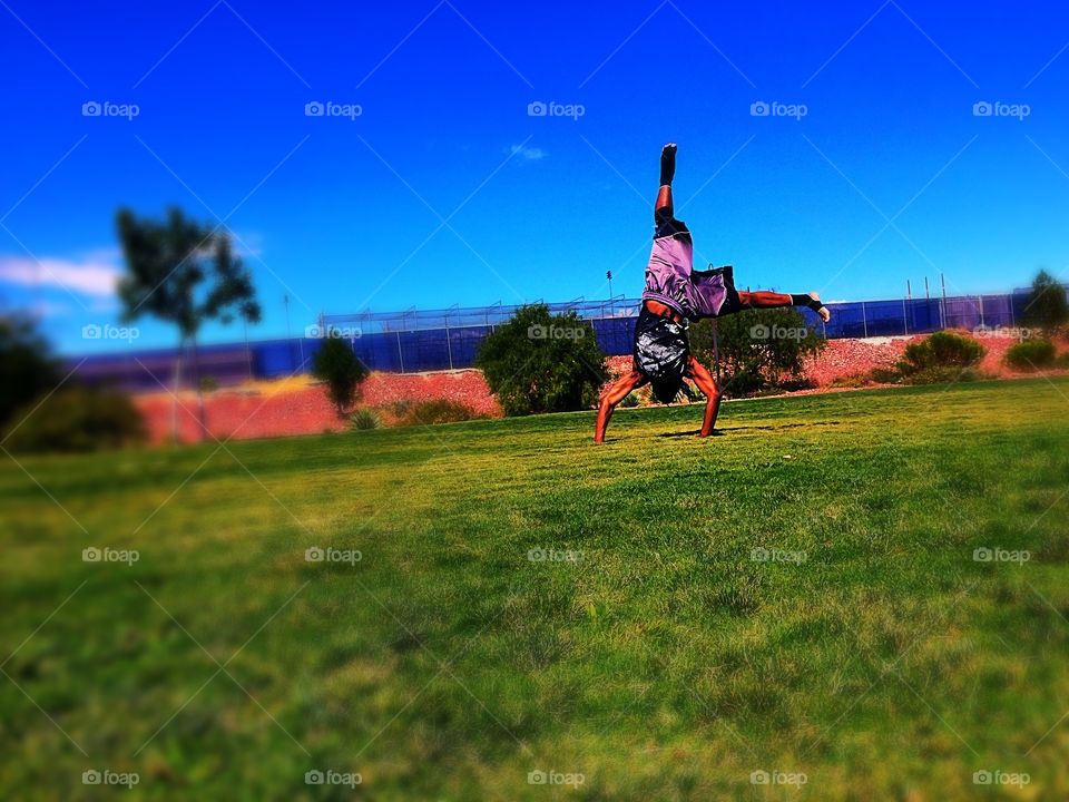 Back flips in the park . Kid in the park practicing his flips 