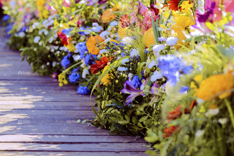 Amazing colorful flower arrangements displayed along a wooden bridge