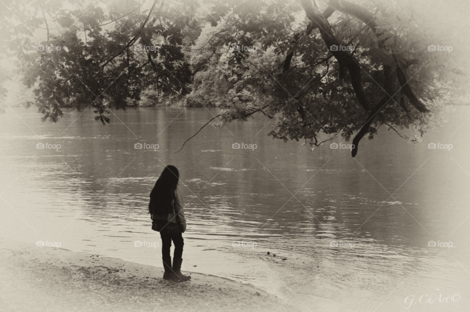 Rear view of girl standing near lake