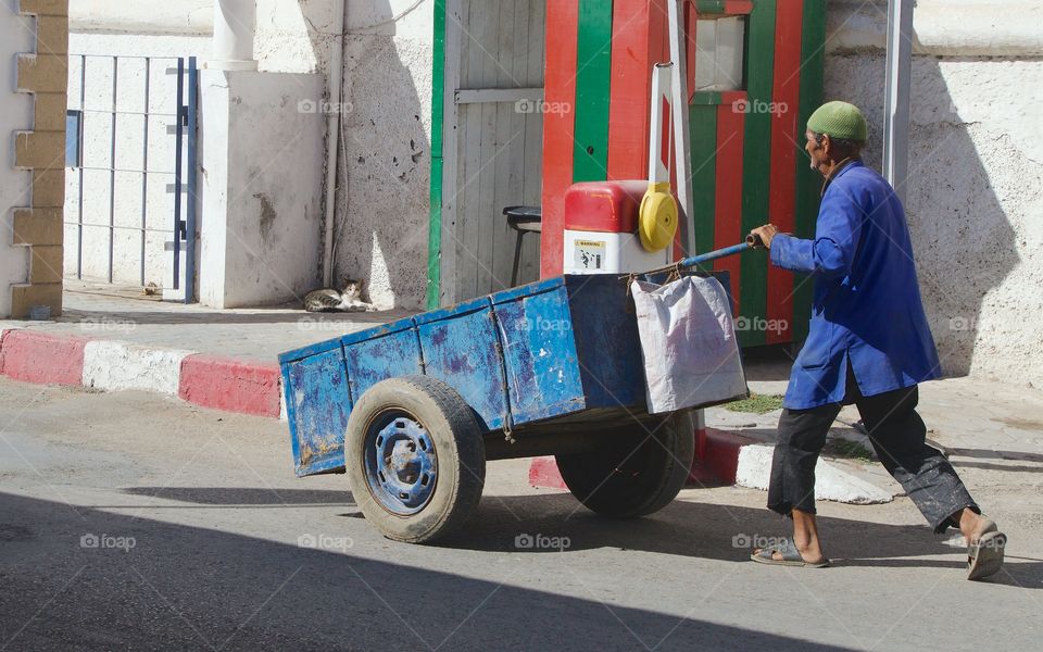 A man pushing a cart in Essaouira, Morocco, North Africa.
