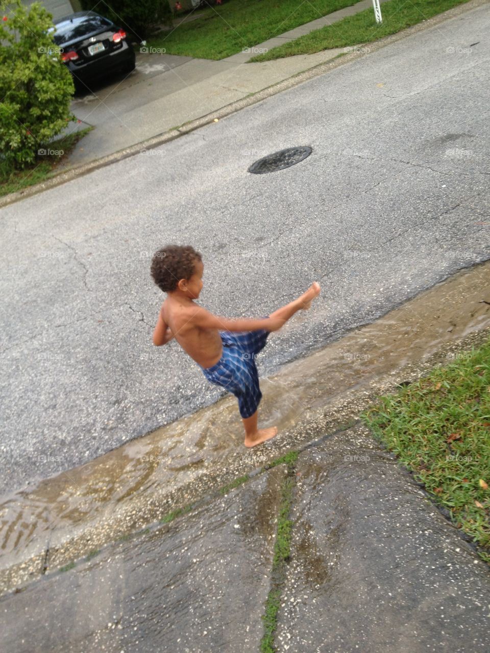 Kid Kicking Puddle