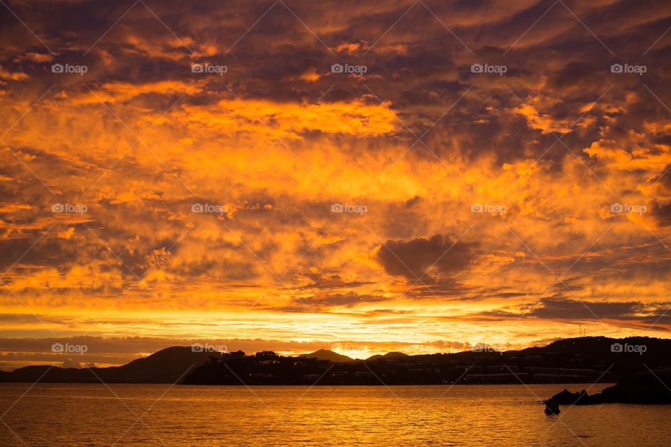 Sunset over mountainous caribbean island from the water