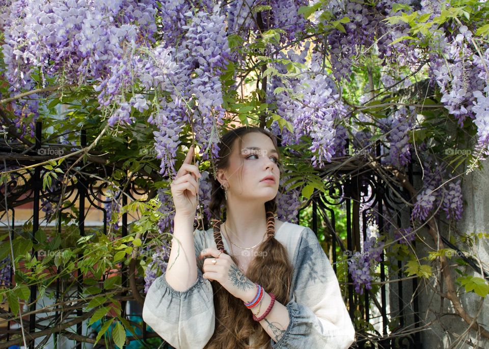 Portrait of Young Girl on Background of Purple Flowers