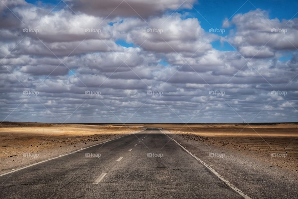 Cluldy day and long road in desert