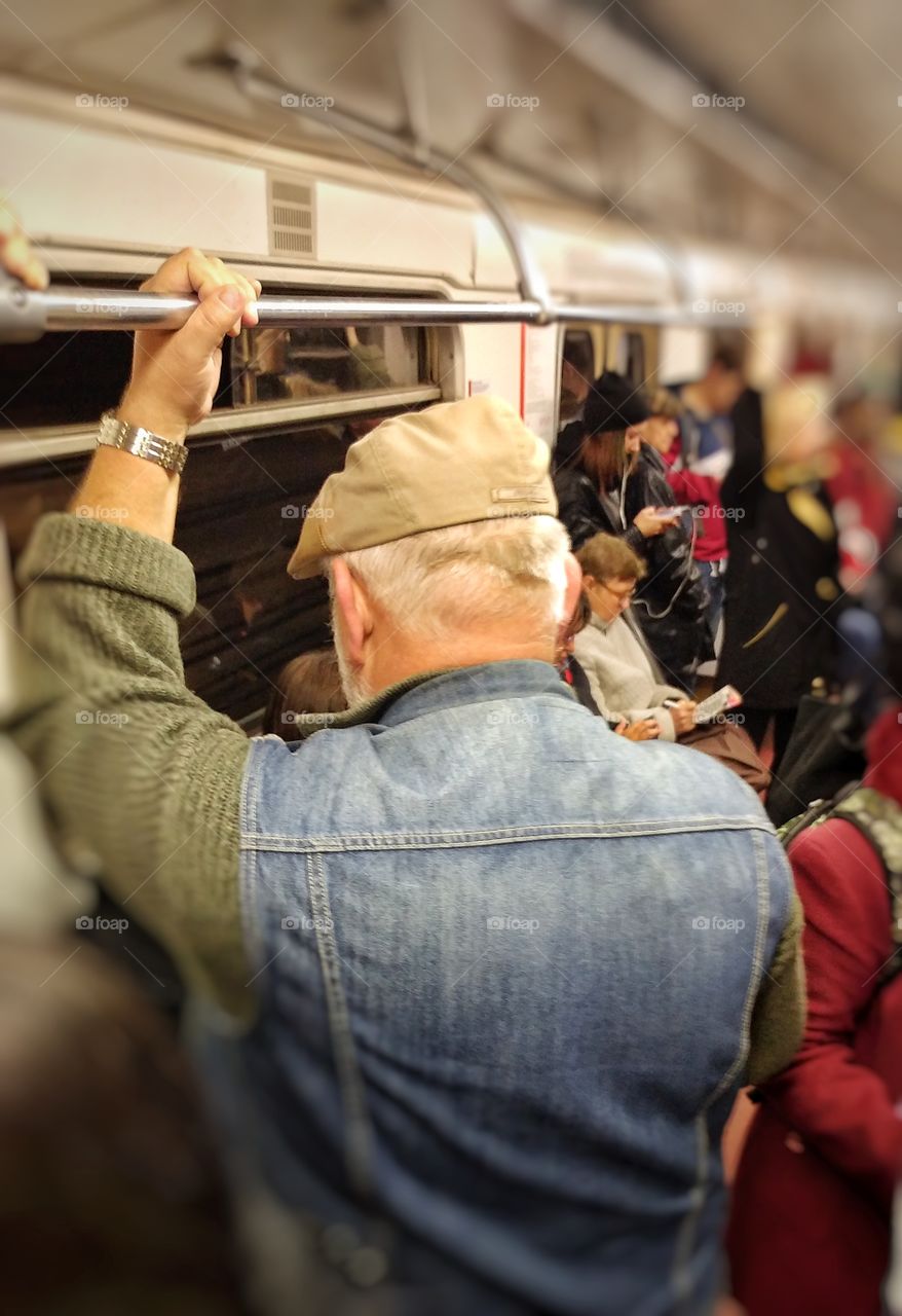 I noticed this older nan in a crowd. He is retired but kook strong. I was riding a subway in a same car.