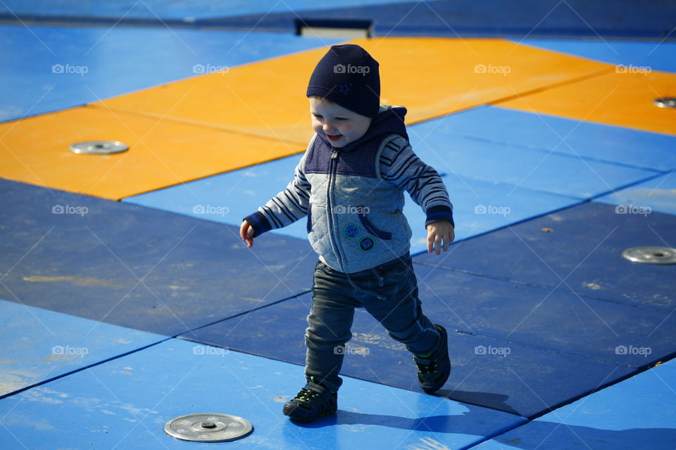 Boy playing in out if order water splash fountain
