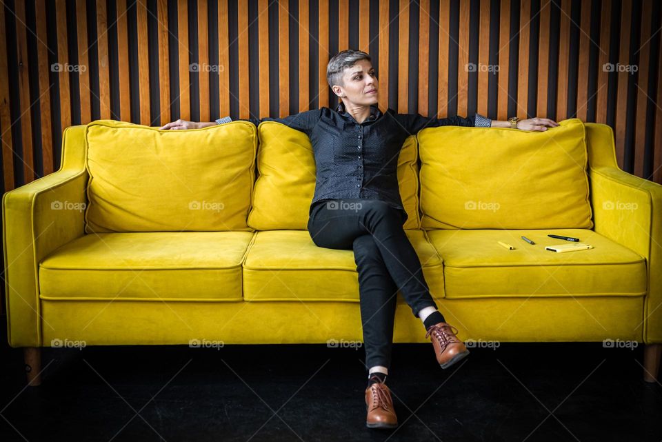 Woman sitting on yellow sofa