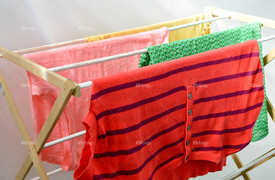 Colorful shirts hanging on a drying rack