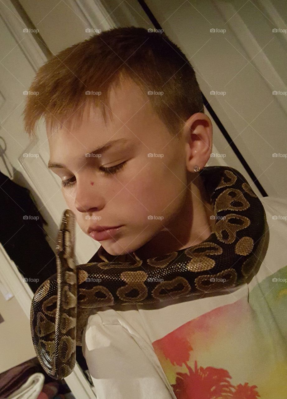 a boy with his pet ball python