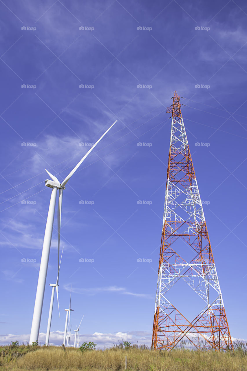 Wind turbines generate electricity and High voltage transmission towers on the Moutain at Khao Kho of phetchabun in Thailand.