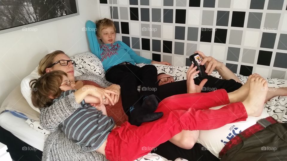 Family resting on bed