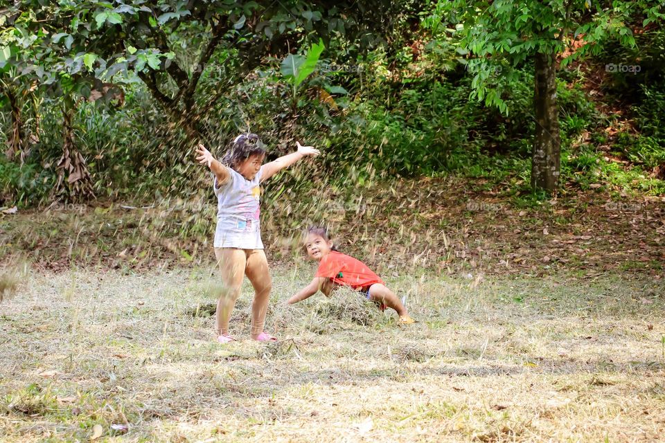 Child playing with dry grass.