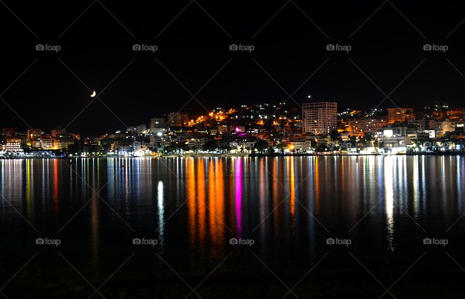 City Saranda Lights Reflected on Body of Water During Night