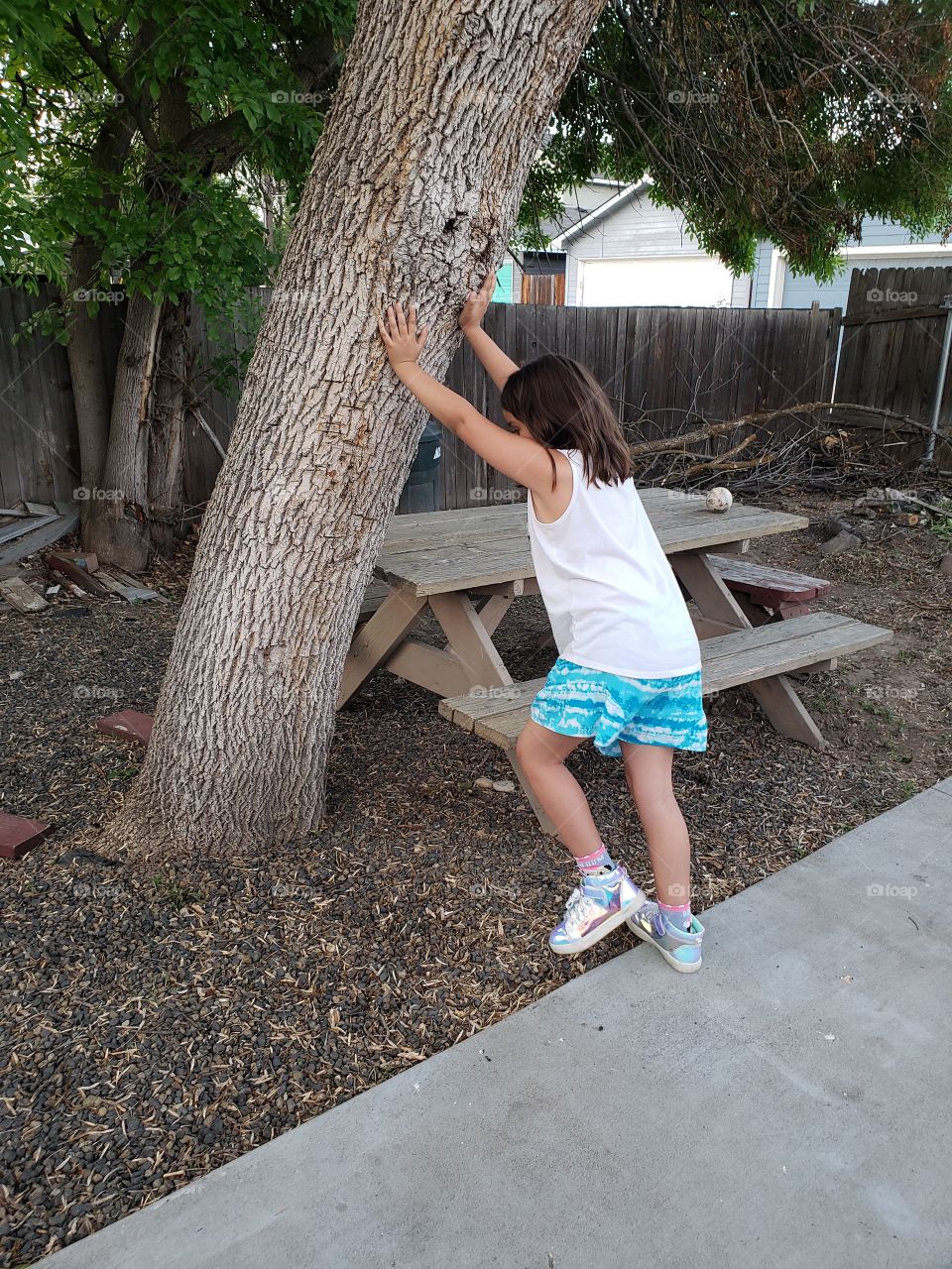 girl holding up a tree, leaning tree