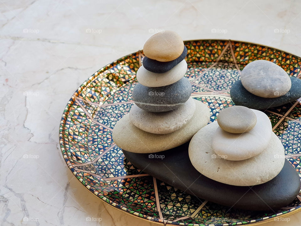 colourful pebbles arranged balancing on a beautiful plate