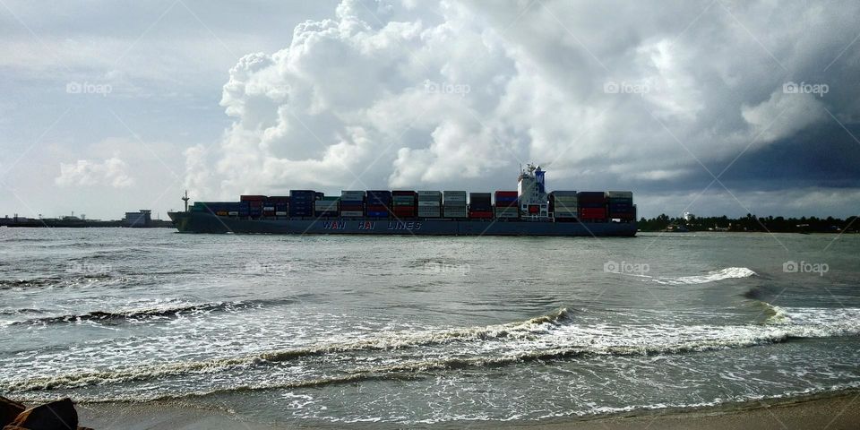 Clouds looks bigger than the Ship!, Cargo ship which begins its journey on a cloudy day, view from the beach, Beautiful clouds