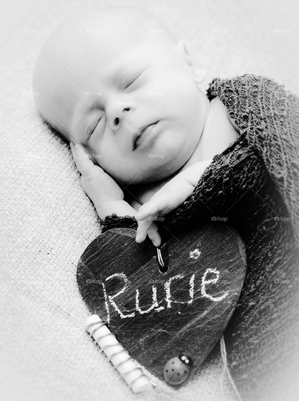 Baby kid sleeping on bed with heart shape name label
