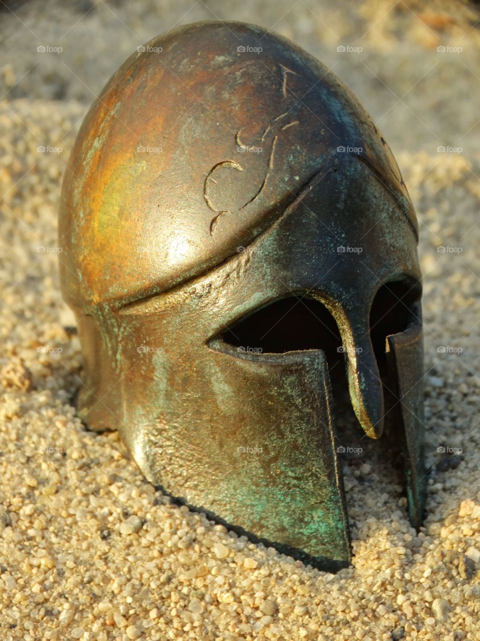 Spartan Warrior's Helmet. Spartan Hoplite Helmet In The Sand During The Golden Hour
