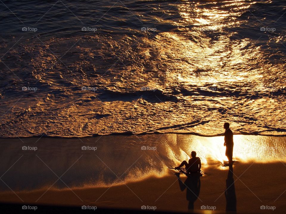 Silhouette of people at beach during sunset