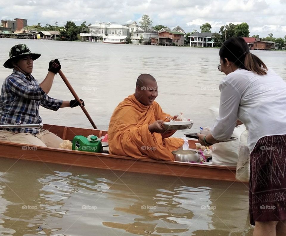 It's a ceremony of giving alms to monks by water, which happens only once a year.