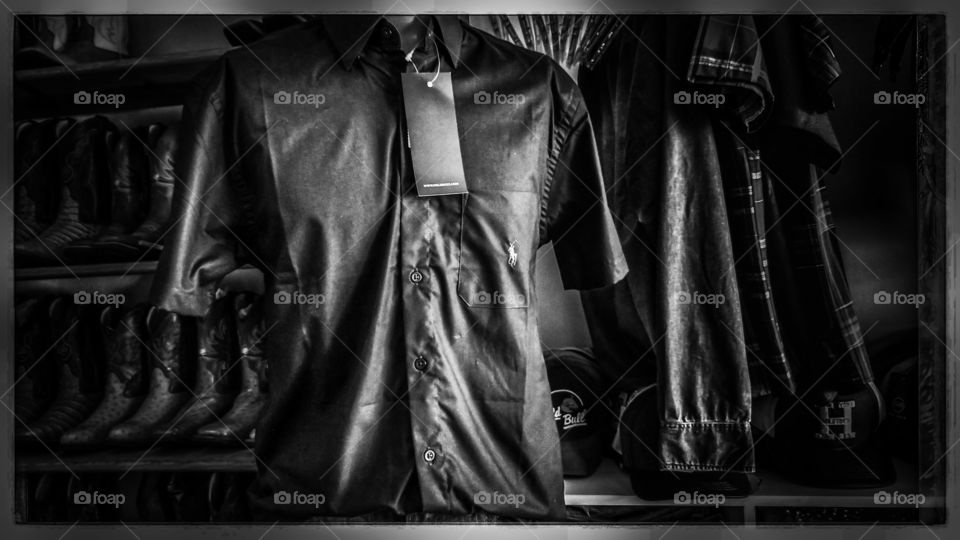 Loja de roupas. Camisas e camisetas, cabides, mostruário, calçados, manequim.