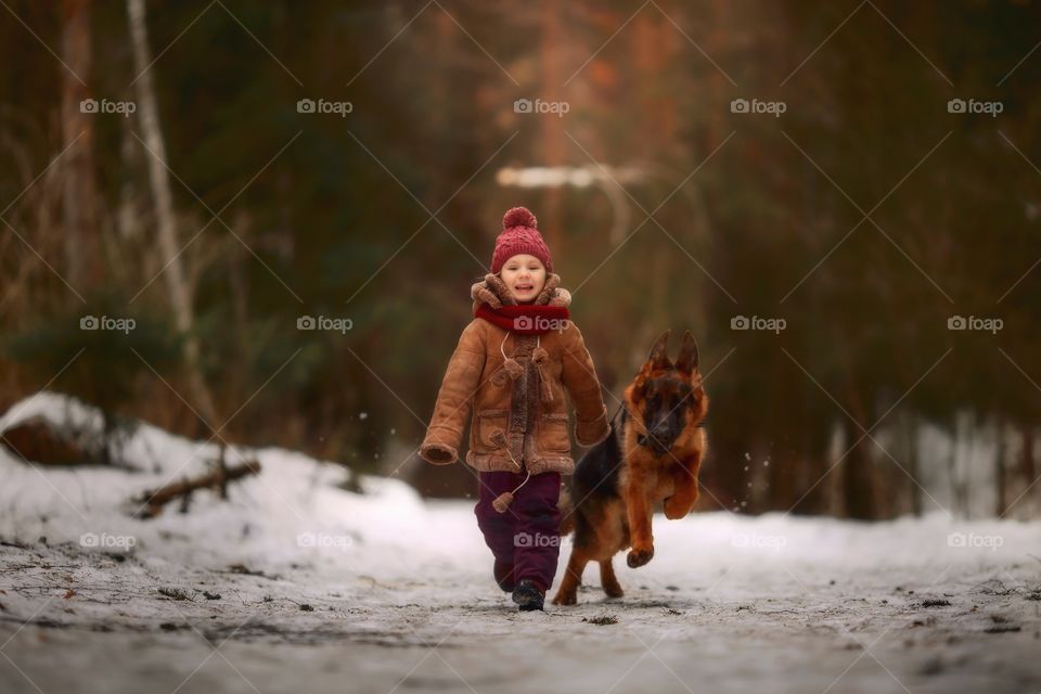 Little girl with German shepherd dog in a spring park 